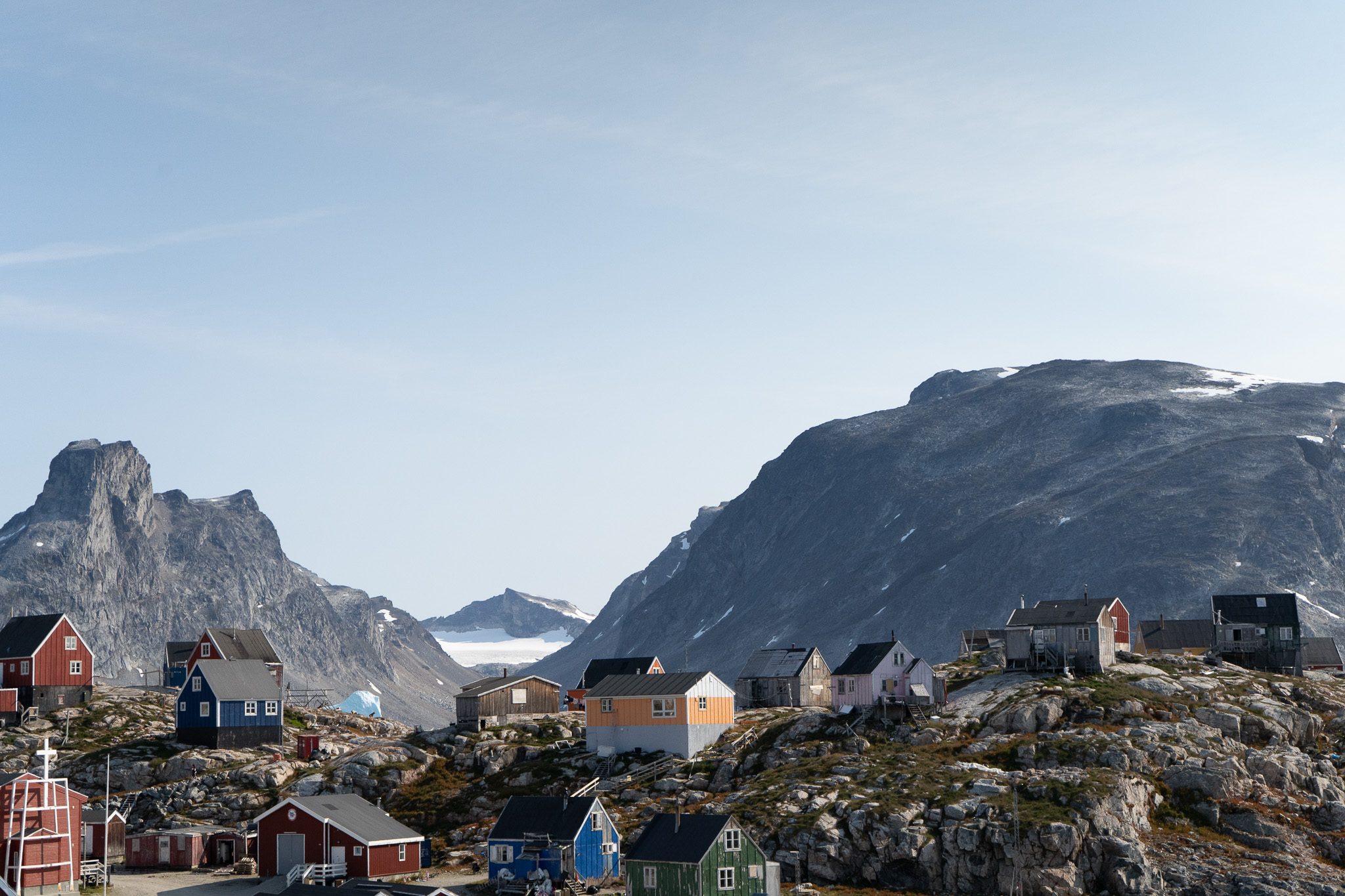 View of the small houses contrasting the majestic mountains. Photo by Visit East Greenland