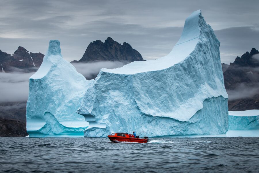 A boat from Arctic Dream passing a rather large iceberg near Tasiilaq in East Greenland. Photo: Mads Pihl - Visit Greenland