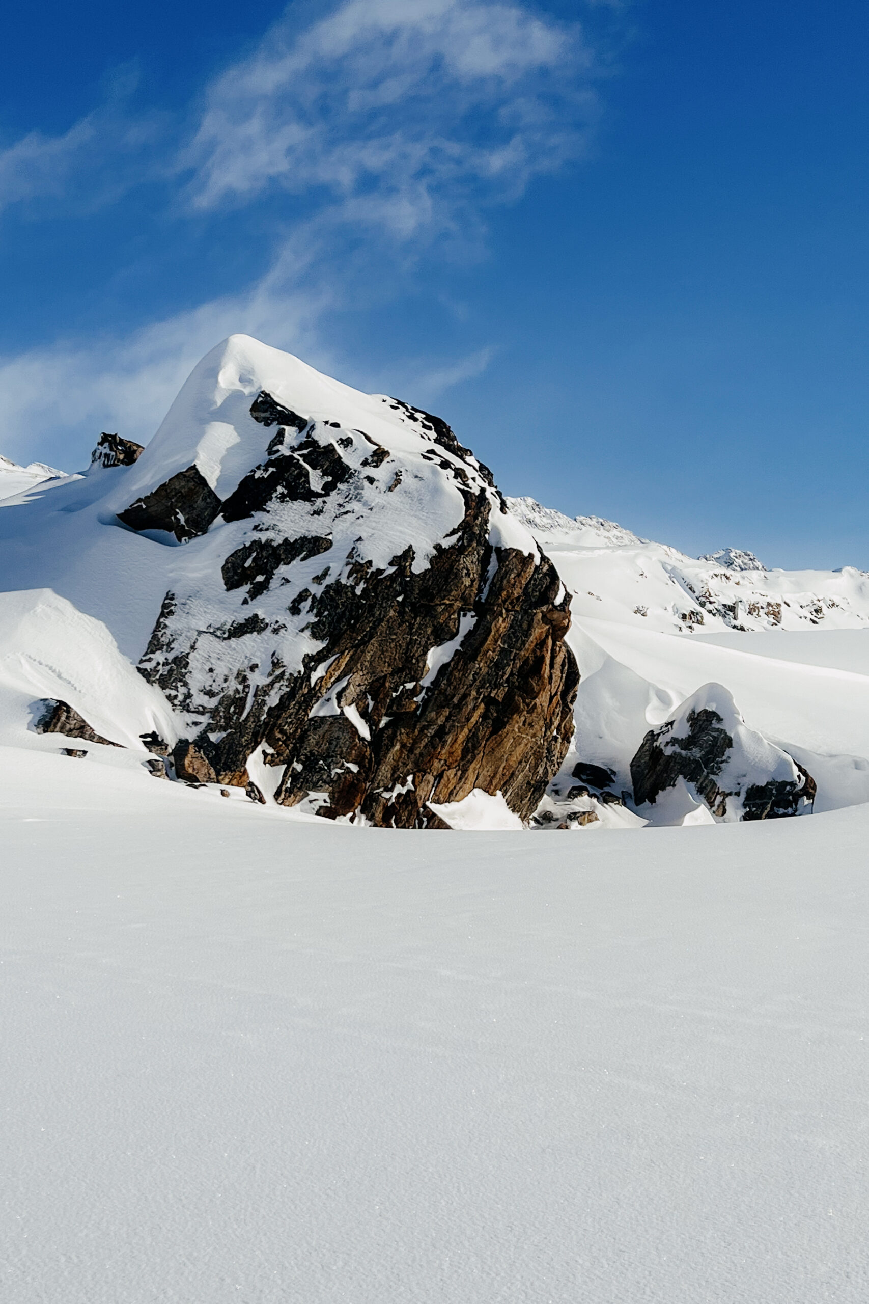Snow-covered mountain ridge view on Ammassalik Island.