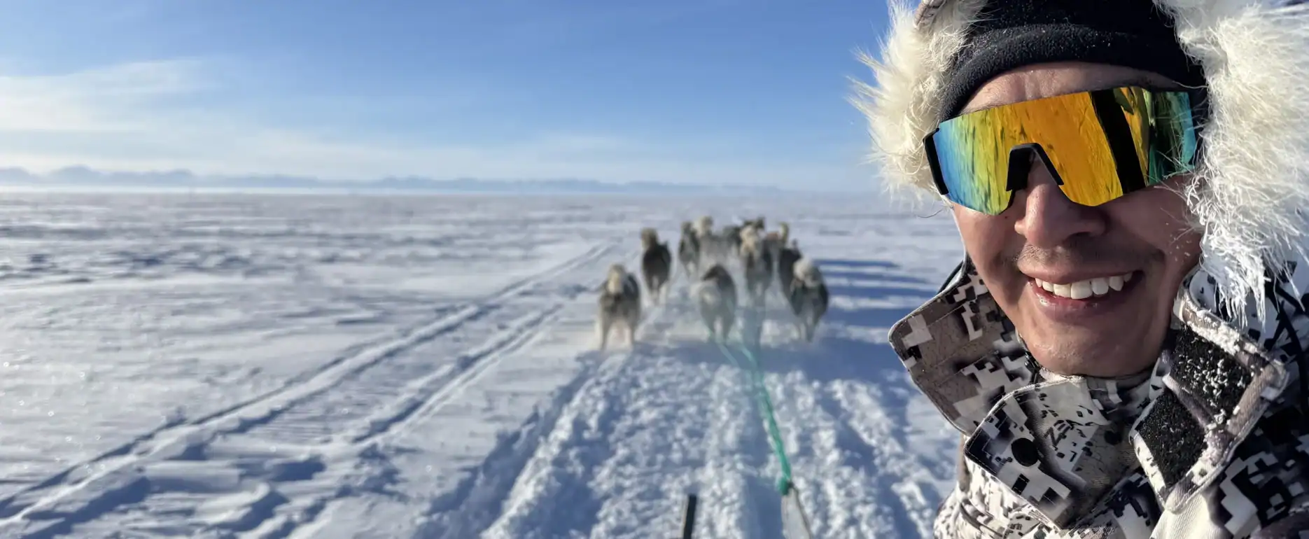 Musher Martin sitting on the dog sled while crossing the frozen sea ice outside Ittoqqortoormiit.